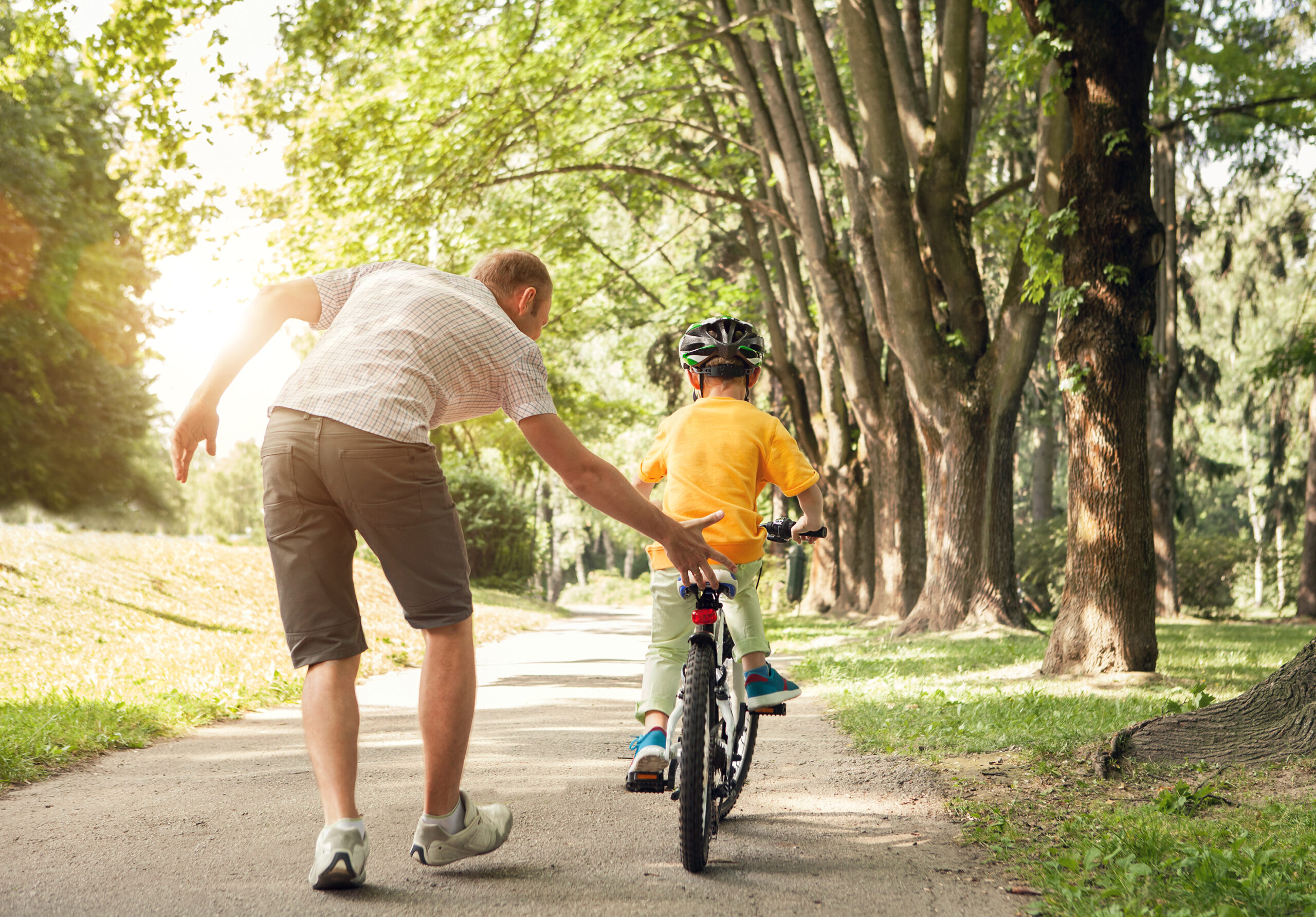 Father teaches his son to ride a bicycle
